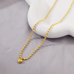 Minimalist gold heart pendant necklace with elegant oval rice bead chain on display