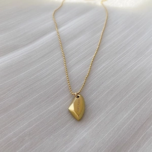 Elegant gold heart pendant necklace with Love Today engraving on white fabric