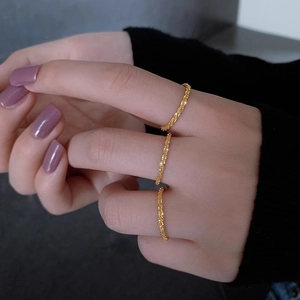 Three-piece set of textured 18k gold-plated thin stackable rings on a model's hand