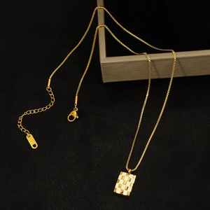 Gold chessboard rectangular pendant necklace with K18 engraved clasp on black background