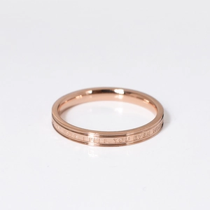 Detail of rose gold titanium steel ring featuring deep laser-etched English lettering