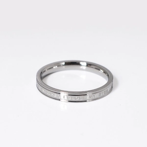 Macro shot of silver titanium steel ring with engraved 'EVEN WHEN I CLOSE MY EYES' text