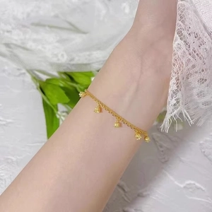Detailed view of elegant double-layer gold lily of the valley bracelet on female wrist