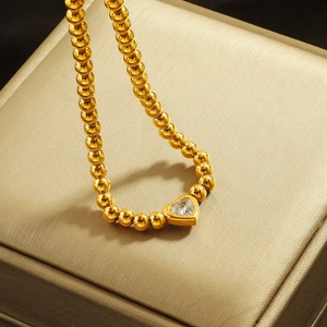 Fashionable beaded heart zircon necklace in gold finish displayed on silk gift box