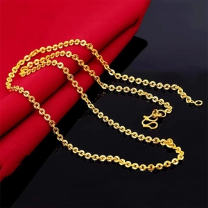 Detailed macro view of golden O-chain necklace with S-hook clasp on red fabric