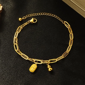 Gold double-layer hulu bracelet for women with lucky charm tag on black background