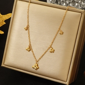 Polished gold butterfly pendant necklace elegantly displayed on a champagne jewelry box