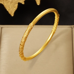 Vintage 4mm gold-plated bangle with bauhinia and scroll pattern in a jewelry box