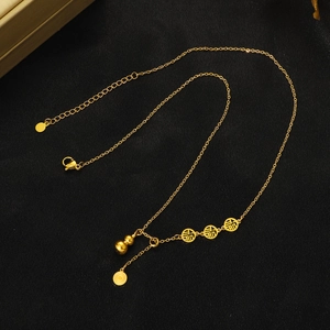 Détail macro des breloques évidées caractère Fu dorées et pendentif gourde sur fond noir