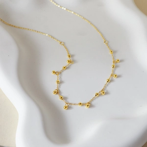Collier minimaliste à franges de perles en or 18 carats sur plateau ondulé blanc