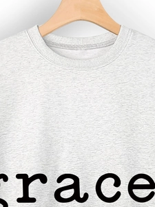 Close-up of light grey heather knit sweatshirt with ribbed crew neck and black heart print