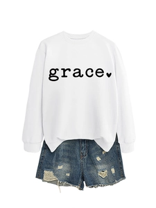 Detail of white grace heart print sweatshirt and distressed denim shorts with frayed hems