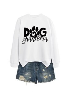 Flat lay of white long sleeve sweatshirt with black Dog Grandma print and denim shorts