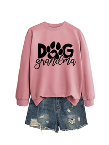 Flat lay of pink Dog Grandma sweatshirt with distressed blue denim shorts on white background