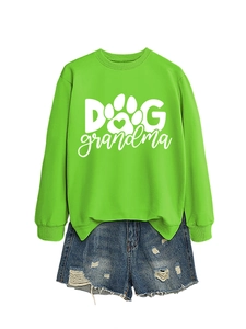 Flat lay of green Dog Grandma sweatshirt with paw print design and distressed denim shorts