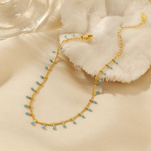 Macro shot of 18K gold plated chain with blue teardrop pendants and lobster clasp