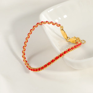 Elegantes rotes Fadenarmband mit Goldperlen und Karabinerverschluss auf Keramik