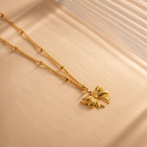 Vintage gold butterfly pendant necklace with textured detail on delicate bead chain