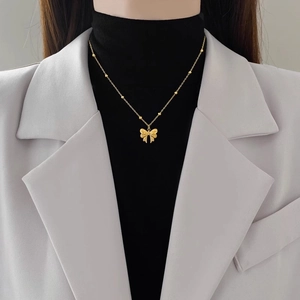 Elegant gold bow pendant necklace for women with a delicate beaded stainless steel chain