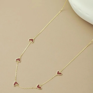 Elegant gold chain necklace featuring five burgundy enamel heart pendants on leather