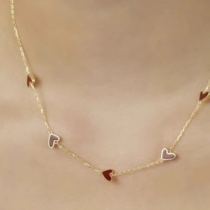 Golden necklace with five alternating dark red and pink enamel hearts for women