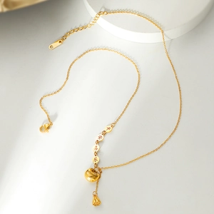 Detailed macro view of gold plated lotus pod and peace lock pendants with tassels