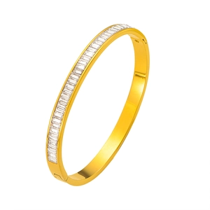 Bracciale in titanio dorato lucido con intarsio di zirconi baguette, vista a 45 gradi