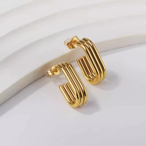 Polished gold multi-layer U-shaped titanium steel earrings on a minimalist white display