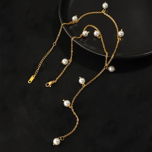 Elegant gold necklace with multiple white pearls and a K18 engraved tag on black background