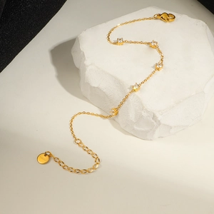 Bracelet en acier inoxydable doré avec cinq petits zircons blancs à quatre griffes