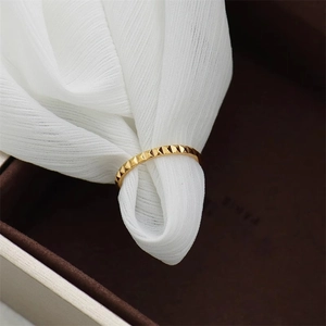Gold pyramid rivet band ring in titanium steel on dark velvet jewelry box