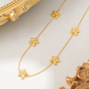Elegante 18K vergoldete Halskette mit fünfblättrigen Blumenanhängern auf Hintergrund