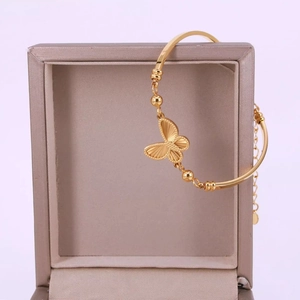 Elegant gold butterfly bracelet with laser-cut wings on a jewelry gift box display