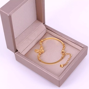 Elegant gold butterfly bracelet with curved bar and adjustable chain in a gift box