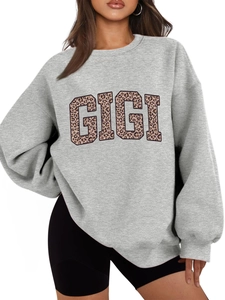 Close-up of oversized grey crewneck sweatshirt with leopard print GIGI lettering text