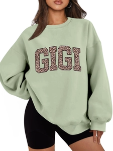 Detail of GIGI leopard print lettering on mint green oversized fleece sweatshirt