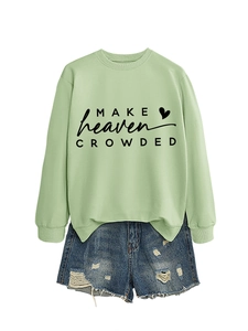 Detail of mint green sweatshirt with letter print and distressed denim shorts with fringe