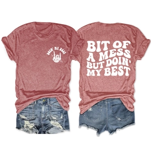 Flat lay of heather red t-shirt with back text and distressed denim shorts set