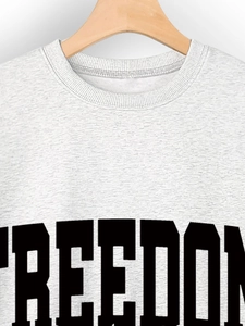Close-up of grey freedom slogan sweatshirt fabric texture and black letter printing