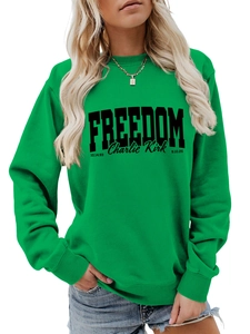 Detail of green long-sleeved sweatshirt featuring black FREEDOM and Charlie Kirk print
