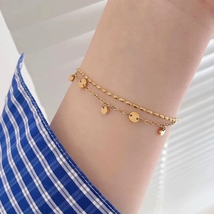 Double-layered gold titanium steel bracelet featuring a bead chain and five round discs