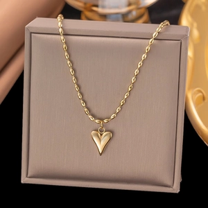 Polished heart pendant necklace with gold beaded chain displayed on a jewelry box