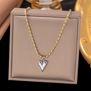 Two-tone gold and silver heart necklace featuring a beaded chain on a premium jewelry display