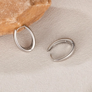Polished silver stainless steel U-shaped horseshoe hoop earrings on a stone textured base