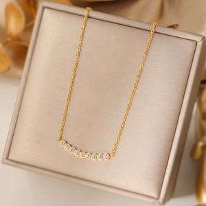 Elegant gold-plated smile necklace with zircon stones on a champagne display box
