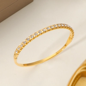 Elegante brazalete de acero de titanio dorado con fila de circonitas blancas refinado