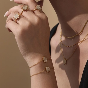 Golden sunburst jewelry set with sparkling zircon inlays on necklaces and rings