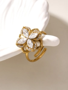 Close-up of rotating 18K gold-plated ring with four-petal flower zircon and adjustable band