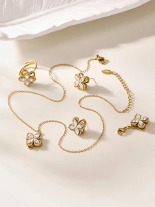 Detail of gold clover jewelry set with sparkling cubic zirconia on stainless steel