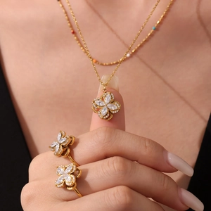 Elegant gold flower jewelry set with spinning clover necklace and matching crystal rings